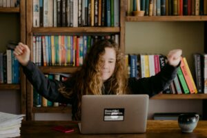 woman in black long sleeve shirt sitting in front of silver macbook